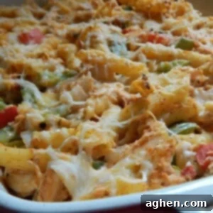 Spicy Fajita Chicken Pasta Casserole 2 A top-down view of the freshly baked Chicken Fajita Pasta Bake in a red casserole dish, showing the browned cheese and colorful ingredients.