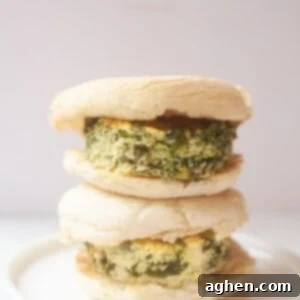 A close up of a spinach and feta egg patty on an English muffin