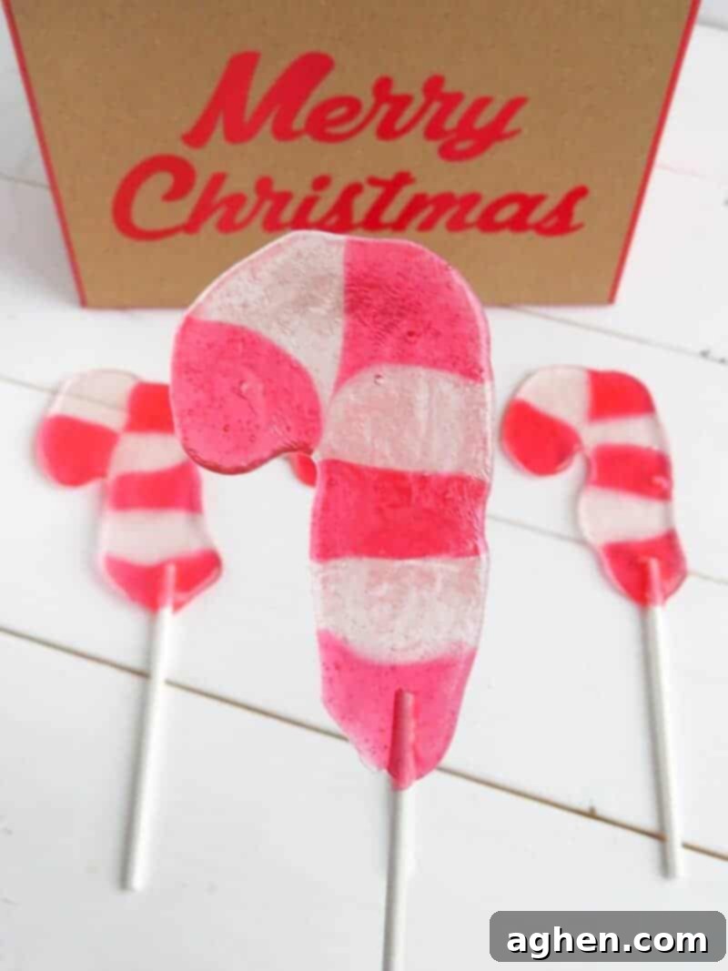 Candy Cane Lollipop on white stick close up with 2 more in background.