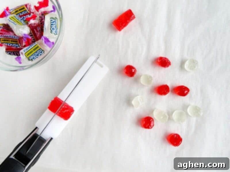 Kitchen scissor cutting jolly ranchers in half.