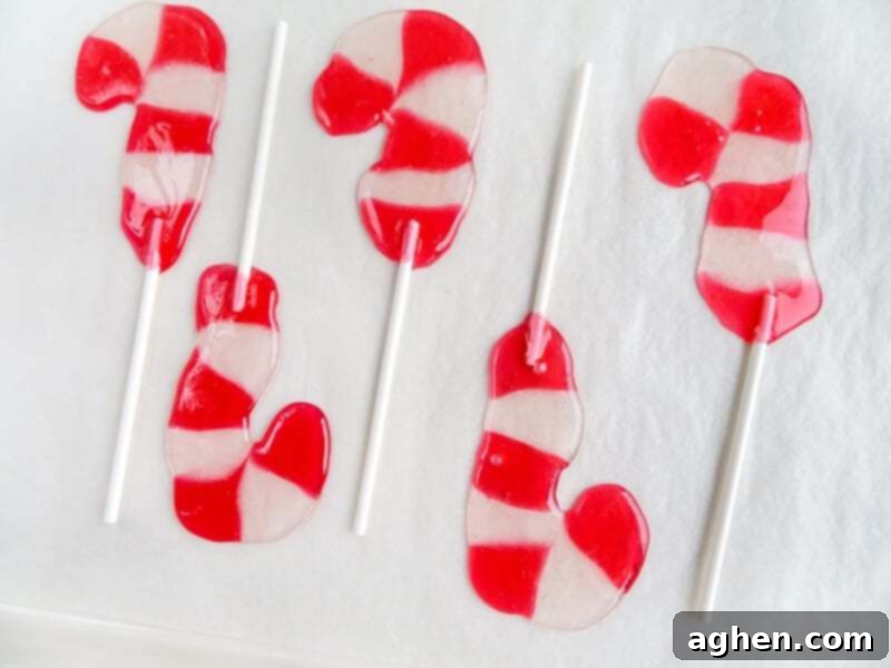 Baking sheet with candies melted together to form candy cane lollipops. 