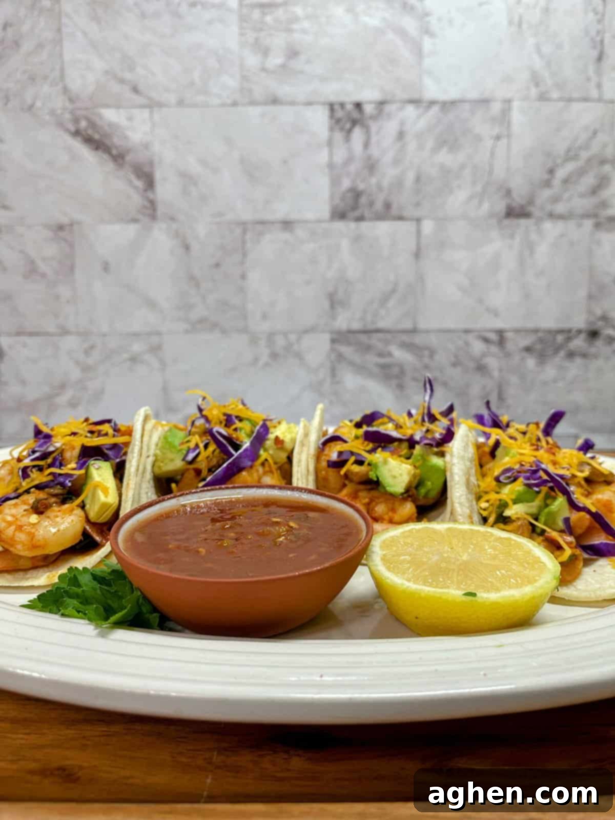 four chipotle shrimp tacos with salsa and a lemon