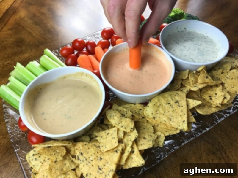 A hand gracefully dips a crisp baby carrot into a creamy, savory dip, emphasizing the delightful act of enjoying a simple, healthy snack.