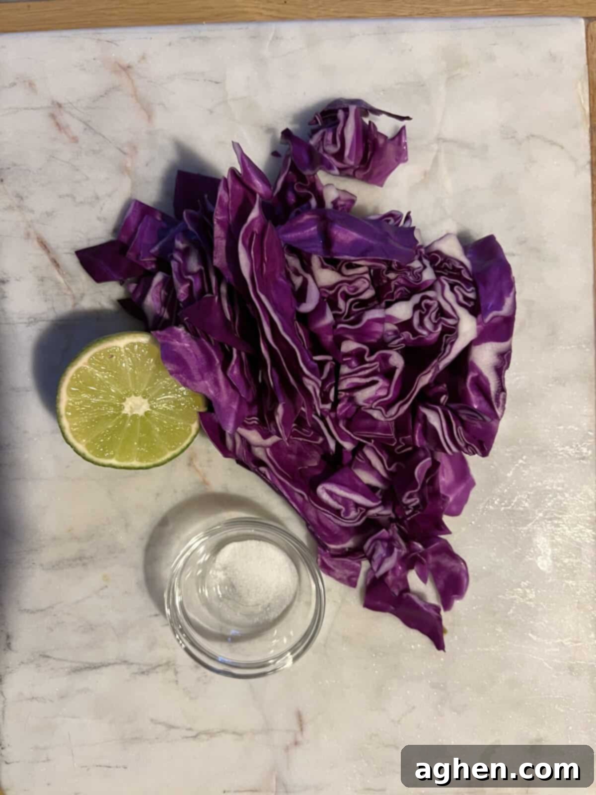 Fresh ingredients for lime cabbage slaw, including a head of cabbage and limes
