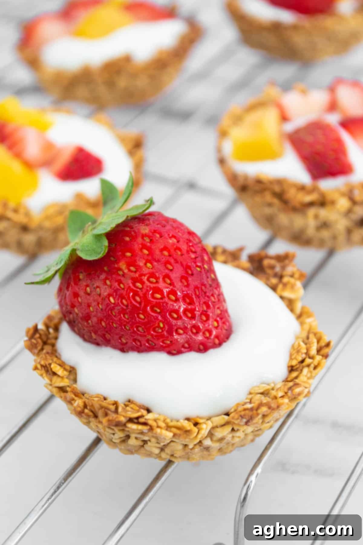 Close-up of a baked oatmeal cup topped with creamy yogurt and fresh sliced strawberries