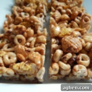 Chocolatey Cereal Squares 2 A square block of chocolate cereal treats with a bite taken out, showing the gooey marshmallow and crispy cereal texture.