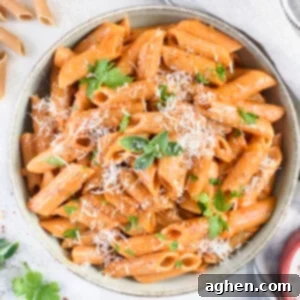 A bowl of finished Healthy Gigi Hadid Pasta, garnished with fresh herbs and a sprinkle of parmesan cheese