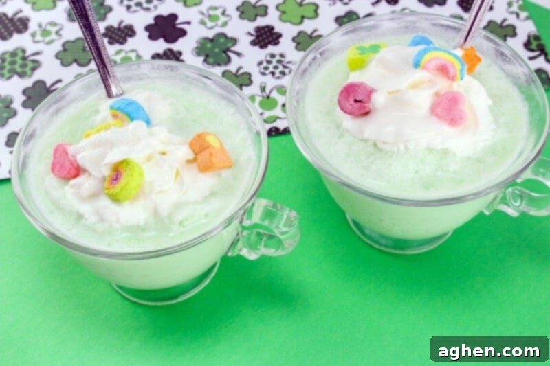 St. Patric's Day Shamrock Frozen White Hot Chocolate topped with lucky charms marshmallows and cool whip.