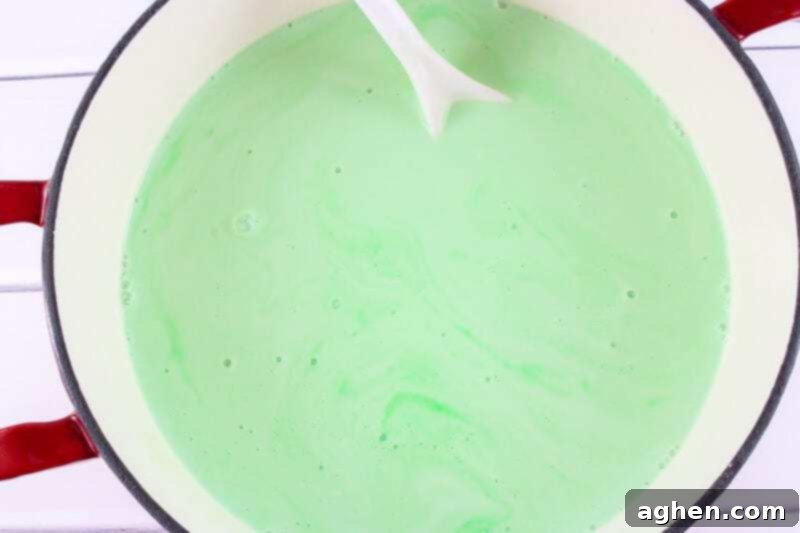Pot with green creamy liquid and white spoon.