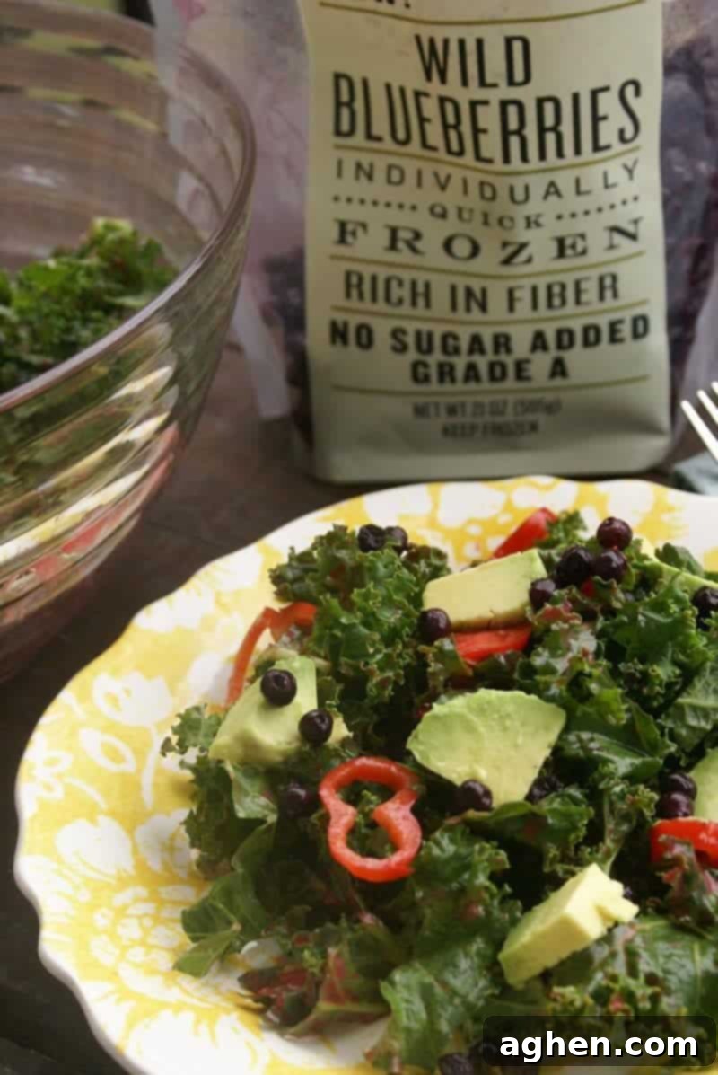 Kale salad with blueberries, avocado, and red chili peppers.