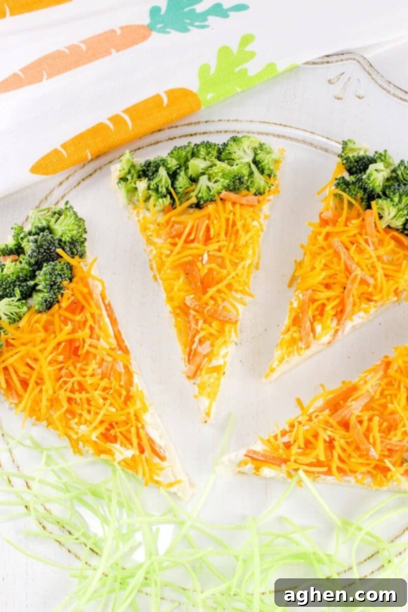 Crescent roll veggie pizza bars topped with shredded carrots and broccoli, arranged to look like carrots. A perfect, colorful, and healthy snack for kids.