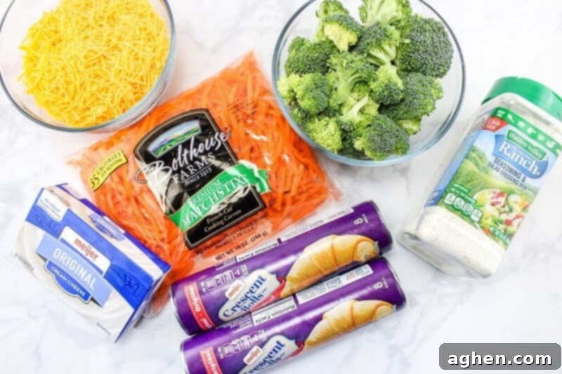 Ingredients on countertop: Fresh broccoli florets, shredded cheddar cheese, bright shredded carrots, refrigerated crescent rolls, creamy ranch dressing, and softened cream cheese.
