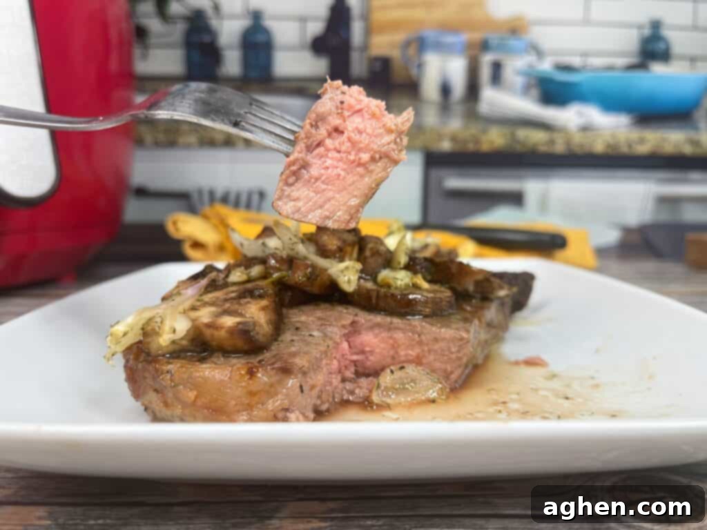 cooked air fryer ribeye steak sliced to show medium-rare doneness