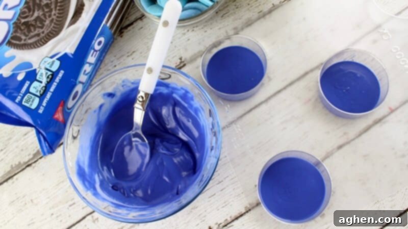 Melted blue candy melts in a glass bowl and added in the bottom of three candy molds.