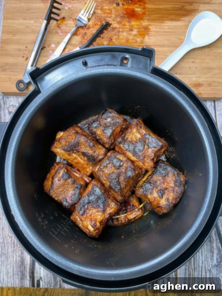 Close-up of seared beef short ribs cooking in the Instant Pot before pressure cooking cycle