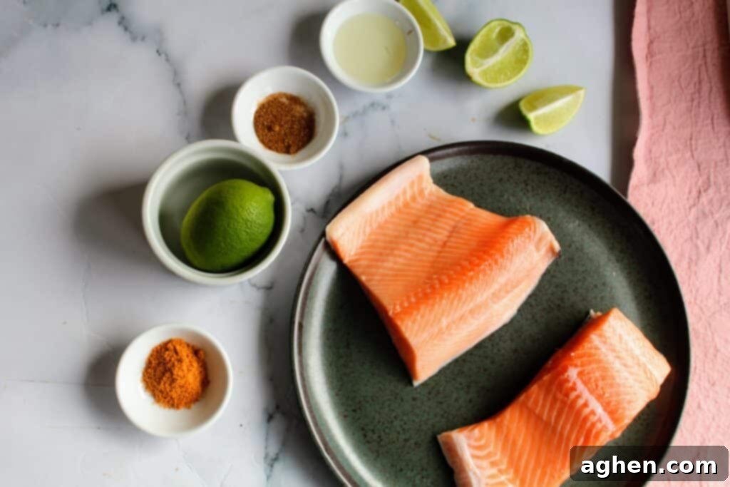 Uncooked ingredients for air fryer salmon bites, including diced salmon, fresh lime, chili powder, and dried basil