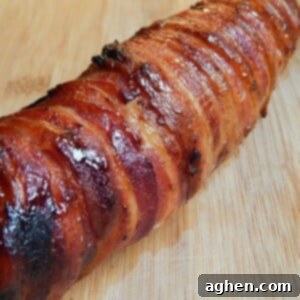 Close-up of maple brown sugar bacon wrapped pork tenderloin on a plate.
