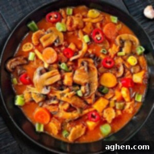 Mushroom Stew: Comfort in a Bowl 2 A generous serving of hearty vegan mushroom stew in a black bowl, garnished with fresh herbs, ready to be enjoyed.