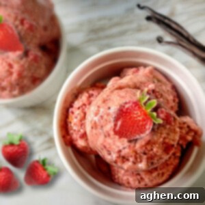 Close-up of creamy vegan strawberry banana ice cream in a white bowl with a spoon