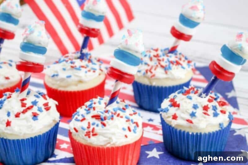 A festive display of 4th of July firecracker cupcakes surrounded by red, white, and blue party decorations, creating a patriotic table setting.