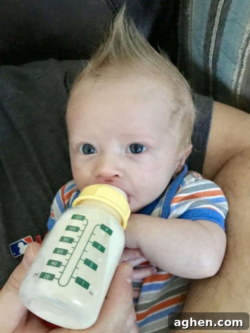Baby Drinking 4 ounce bottle of formula.