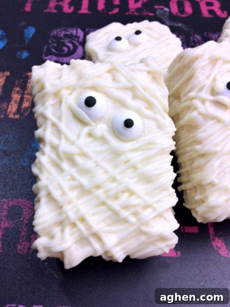 Finished Halloween Mummy Rice Krispie Treats arranged on a white serving tray, ready to be enjoyed.