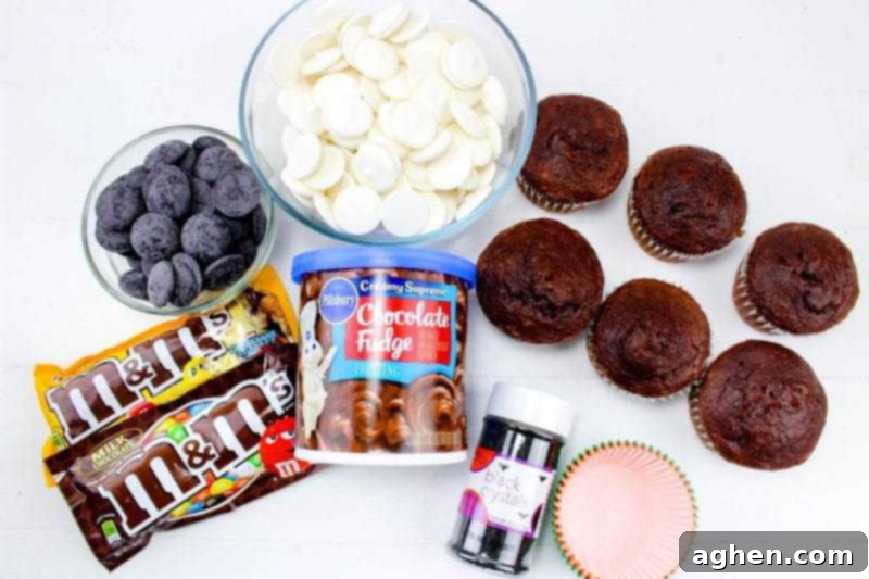 Ingredients for Halloween spider web cupcakes: white candy melts, black candy melts, chocolate cupcakes, chocolate frosting, black sanding sugar, cupcake liners, and various M&Ms.