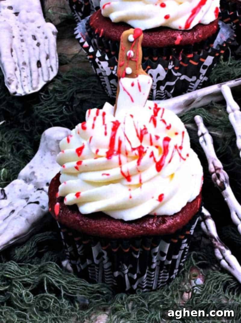Close-up of blood splatter cupcakes with edible blood splatted on top of white cream cheese frosting.