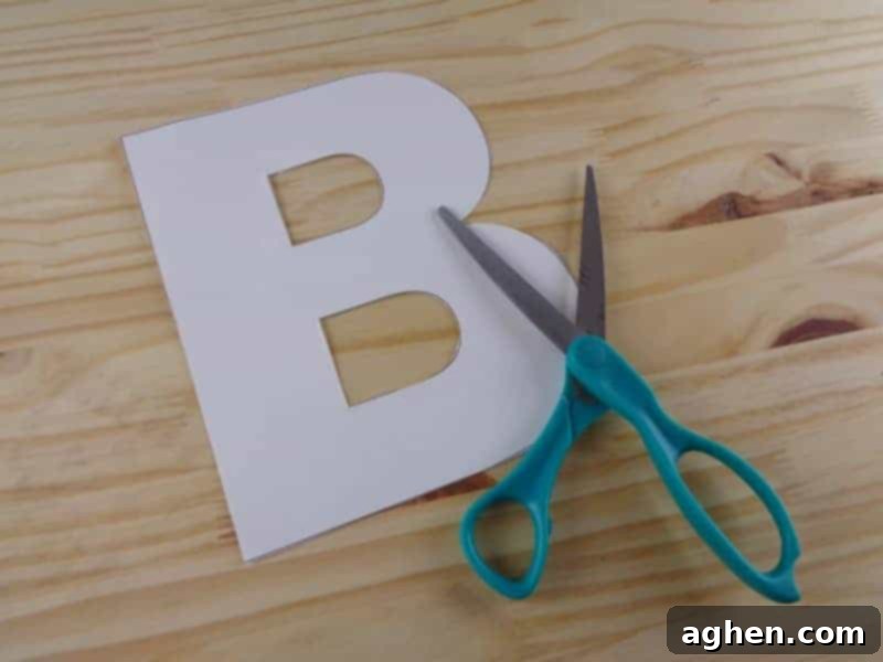 Cutting out the letter B from the printable template to prepare for tracing onto craft foam.
