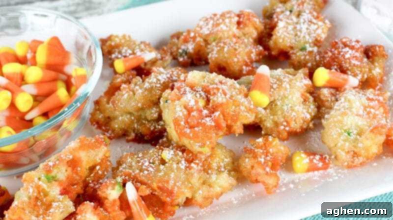 Funfetti Fried Candy Corn Bites 2 Deep fried candy corn in Funfetti batter dusted with powdered sugar and served on a plate with bowl of candy corn.
