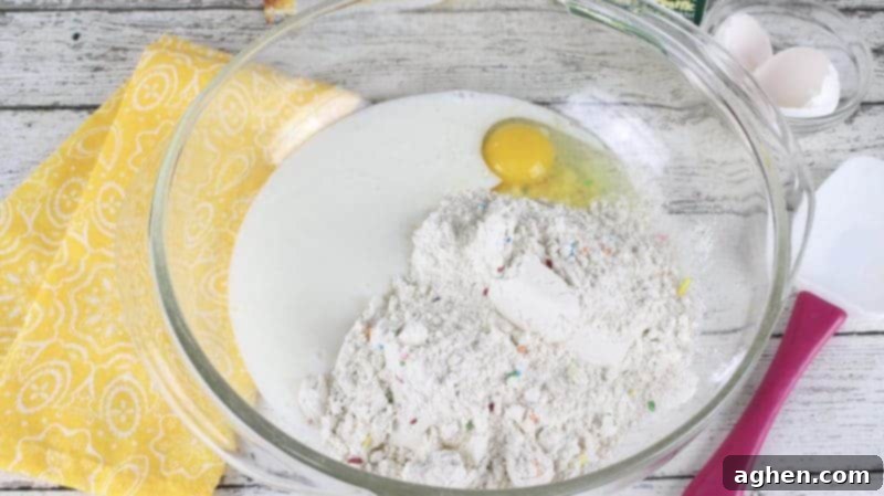 Funfetti Fried Candy Corn Bites 8 Large glass mixing bowl with buttermilk, pancake mix, and egg.