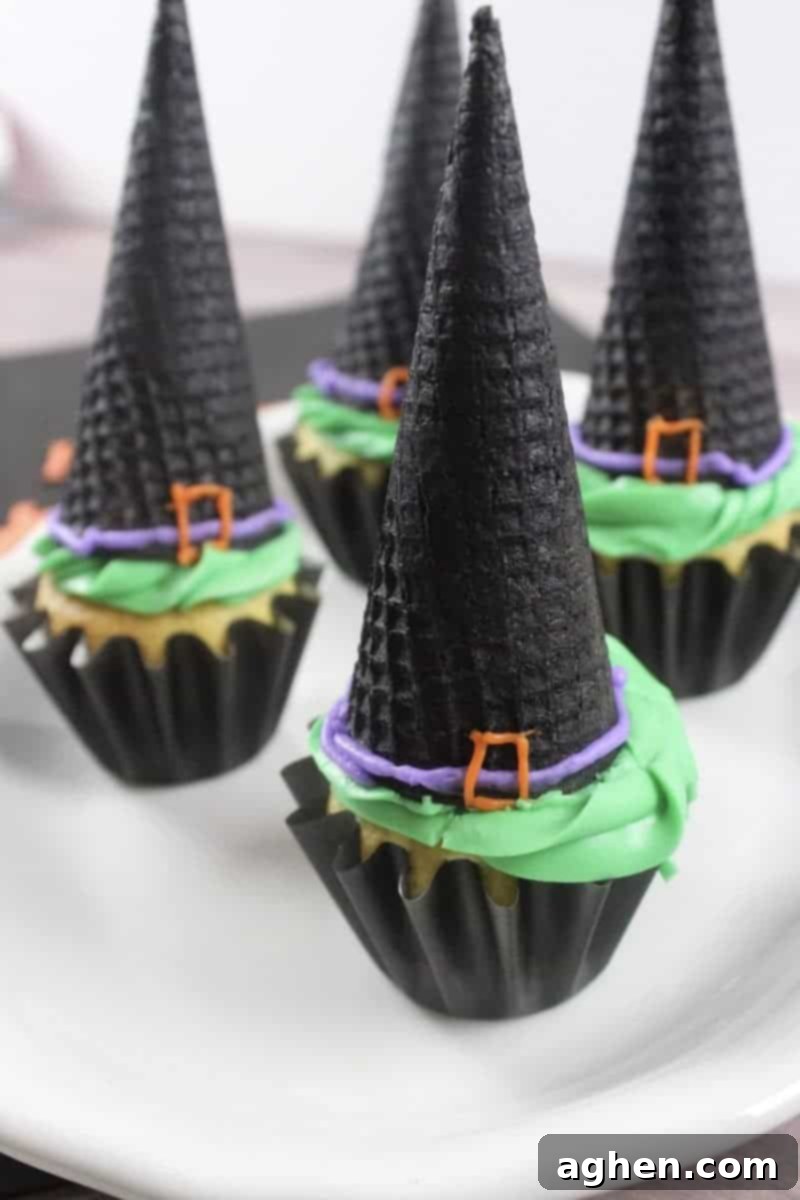 Spooky Witch Hat Cupcakes 2 Witch hat cupcakes made with ice cream cones, green frosting, and black sugar cone hats.