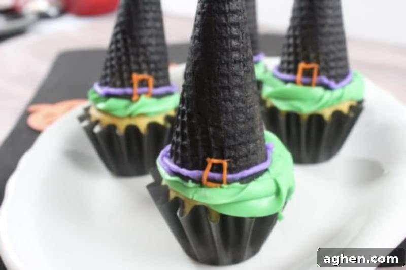 Spooky Witch Hat Cupcakes 3 Vanilla cupcakes in black liners topped with green frosting and black ice cream cones decorated to look like witch hats.