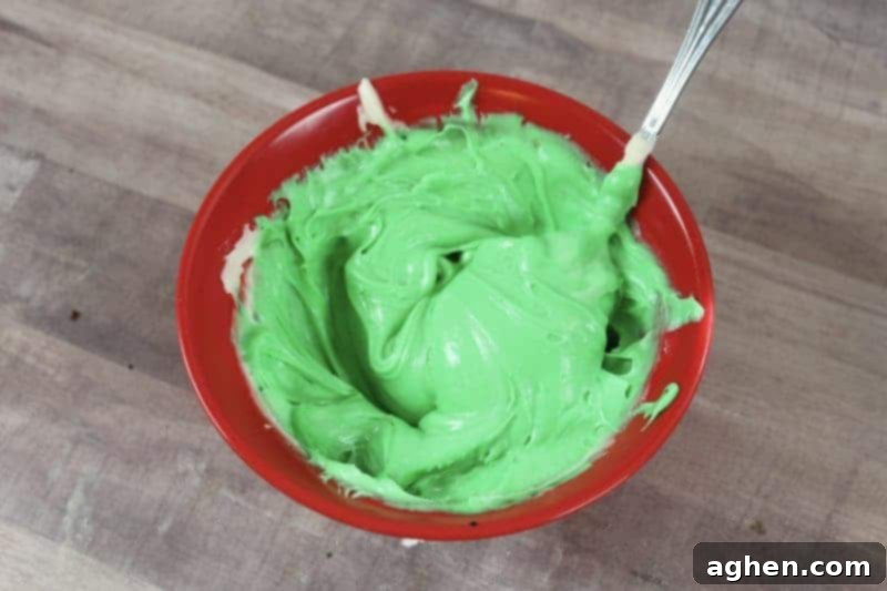 Spooky Witch Hat Cupcakes 6 Green frosting with a spoon in a bowl after mixing with food dye.