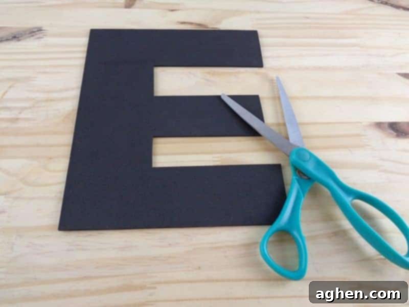 Carefully cut out the traced Letter E from the craft foam or cardstock to create the main body of your 'E is for Ears' craft.