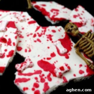Blood splattered white chocolate bark with bone sprinkles, a perfect Halloween treat.