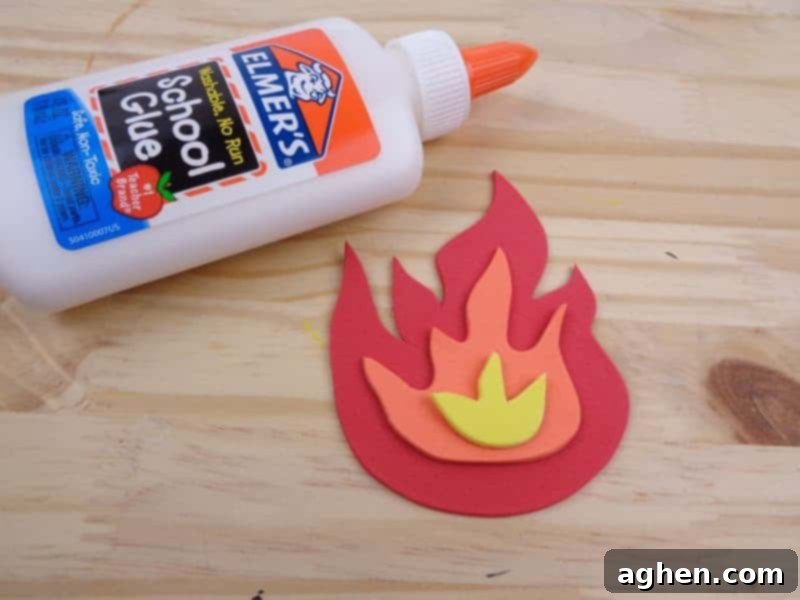 Assembling the craft foam fire by layering red and orange flame pieces to create a dynamic fire effect.