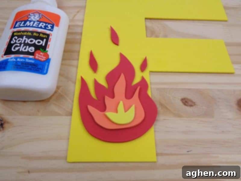 Adding small teardrop or flicker-shaped craft foam pieces in red and orange above the main fire for enhanced detail.