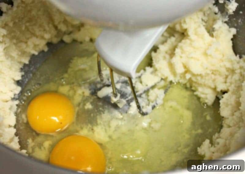 Butter and sugar creamed together in a bowl, with eggs and maple flavoring added for the cake batter.