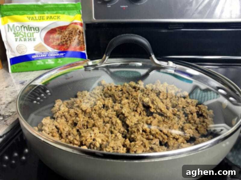 Half of the bread and MorningStar Farms Grillers Crumbles layered in the baking dish for the casserole.