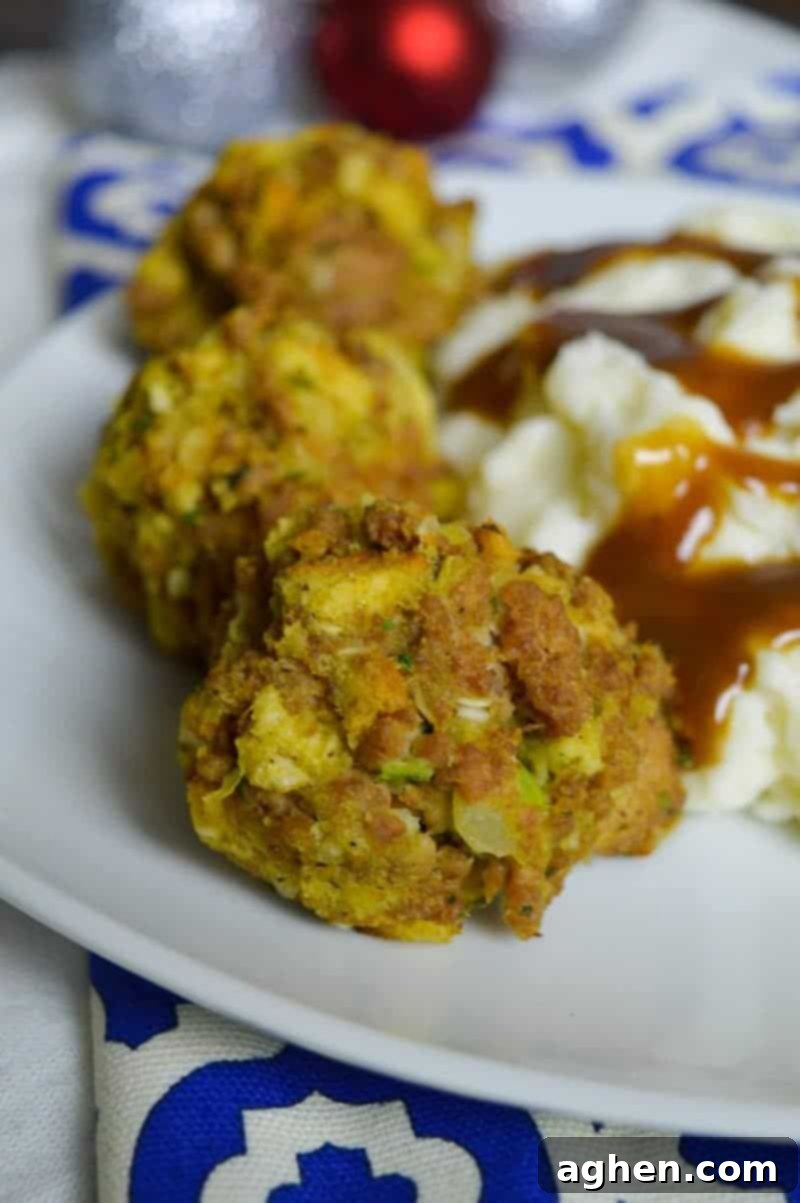 A close-up of several uncooked Turkey and Stuffing Balls on a baking sheet, ready for the oven