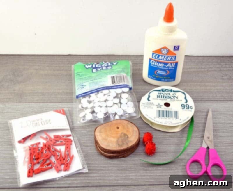 Essential craft supplies laid out: wood slices, craft glue, googly eyes, sparkly red pom-poms, mini red clothespins, ribbon, scissors, and a drill with a small bit.