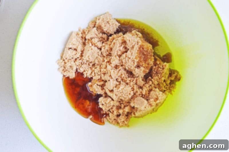 Mixing brown sugar, olive oil, and honey in a large bowl to prepare a natural DIY body scrub.