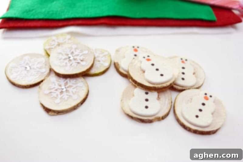 Close-up of DIY Christmas Tic Tac Toe game pieces made from wood slices and festive stickers.
