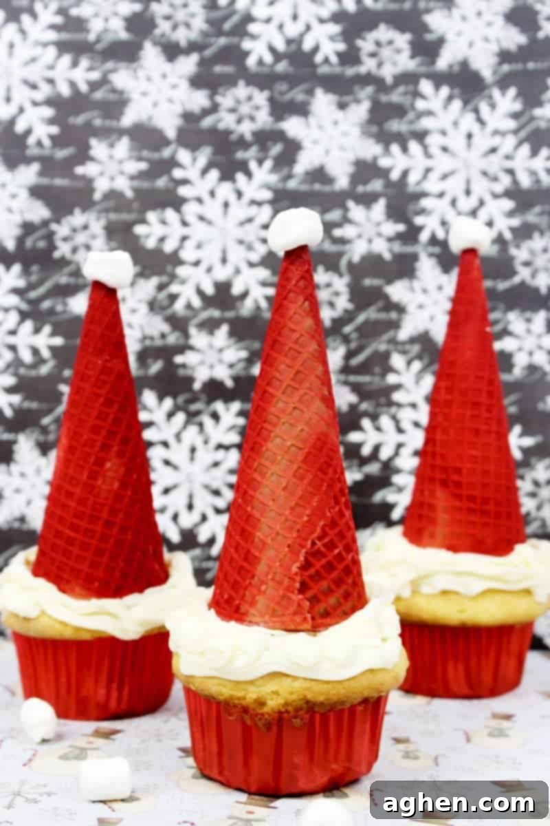 Santa hat cupcakes are made by topping cupcakes with red sugar cones and a mini marshmallow. These fun and easy Christmas cupcakes will definitely be a hit!
