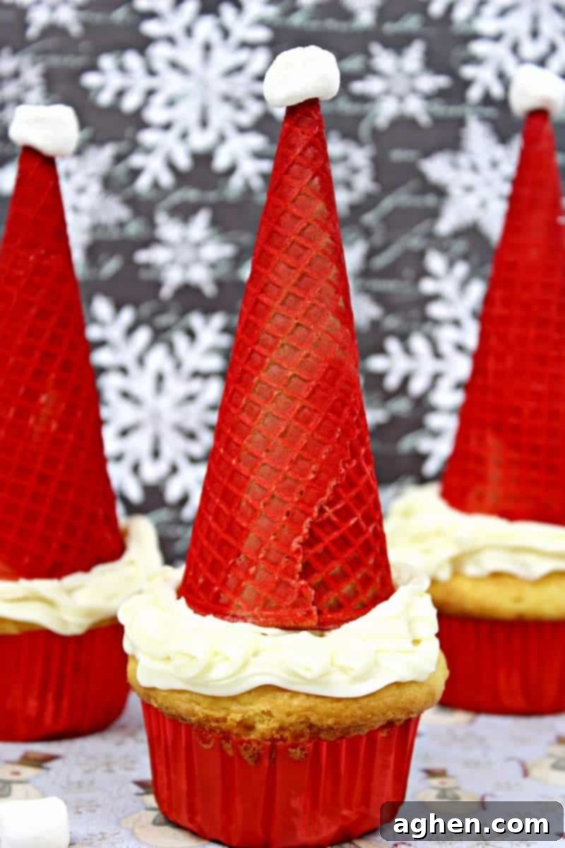 Santa hat cupcakes are made by topping cupcakes with red sugar cones and a mini marshmallow. These fun and easy Christmas cupcakes will definitely be a hit!