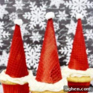 Santa hat cupcakes are made by topping cupcakes with red sugar cones and a mini marshmallow. These fun and easy Christmas cupcakes will definitely be a hit!