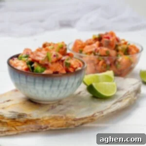Salmon Ceviche in two bowls with lime wedges.