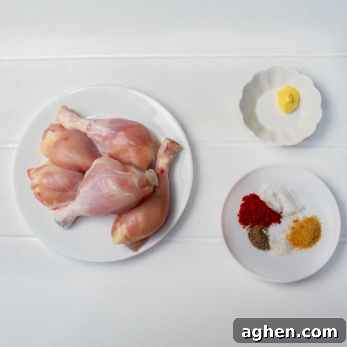Raw bone-in, skinless chicken thighs, a pad of softened butter, and a dish of spices, including smoked paprika, garlic powder, stevia, salt and pepper.