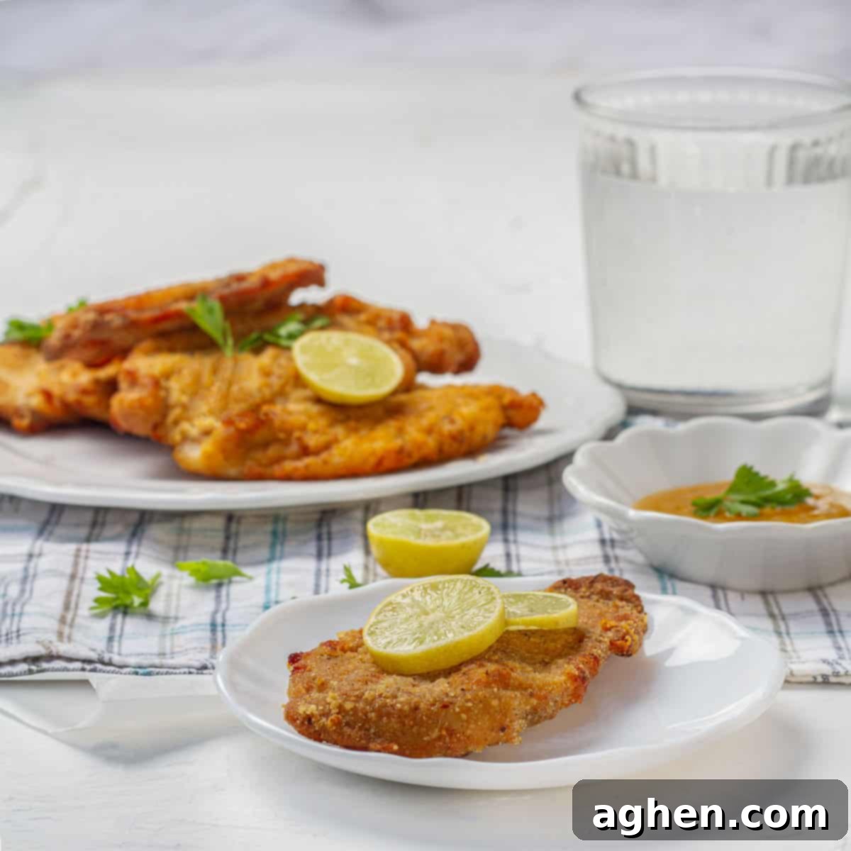 Crispy air fryer chicken cutlets garnished with fresh herbs and lemon slices.